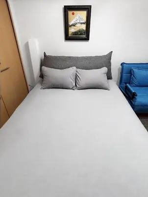 a bed with two pillows and a blue chair at \u65b0\u5bbf\u6b4c\u821e\u4f0e\u753a\u3059\u3050\u306e\u30ca\u30a4\u30c8\u30e9\u30a4\u30d5\u306b\u6700\u9069\u306aWi-Fi\u5b8c\u5099\u8cb8\u5207\u30a2\u30d1\u30fc\u30c8 in Tokyo