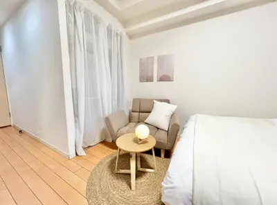 a bedroom with a bed and a chair and a table at \u65b0\u5bbf\u6b4c\u821e\u4f0e\u753a\u3059\u3050\u306e\u30ca\u30a4\u30c8\u30e9\u30a4\u30d5\u306b\u6700\u9069\u306aWi-Fi\u5b8c\u5099\u8cb8\u5207\u30a2\u30d1\u30fc\u30c8 in Tokyo