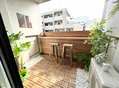 a balcony with two stools and a wooden fence at \u65b0\u5bbf\u6b4c\u821e\u4f0e\u753a\u3059\u3050\u306e\u30ca\u30a4\u30c8\u30e9\u30a4\u30d5\u306b\u6700\u9069\u306aWi-Fi\u5b8c\u5099\u8cb8\u5207\u30a2\u30d1\u30fc\u30c8 in Tokyo