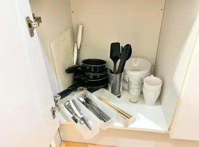 a white cabinet with utensils in a kitchen at \u65b0\u5bbf\u6b4c\u821e\u4f0e\u753a\u3059\u3050\u306e\u30ca\u30a4\u30c8\u30e9\u30a4\u30d5\u306b\u6700\u9069\u306aWi-Fi\u5b8c\u5099\u8cb8\u5207\u30a2\u30d1\u30fc\u30c8 in Tokyo