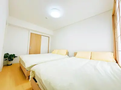 two beds in a room with white walls at \u6587\u4eac\u30cf\u30a6\u30b9301 in Tokyo