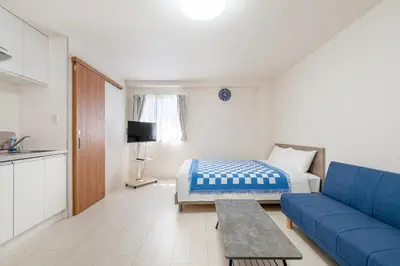 a living room with a blue couch and a bed at -Park Higashiueno- 4-minute walk from Ueno Station in Tokyo