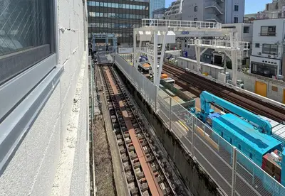 a train on tracks in a city with buildings at -Park Higashiueno- 4-minute walk from Ueno Station in Tokyo