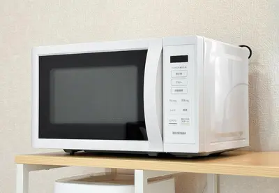 a white microwave sitting on top of a shelf at -Park Higashiueno- 4-minute walk from Ueno Station in Tokyo