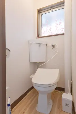 a white toilet in a bathroom with a window at Sakura in Tokyo