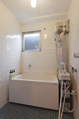 a bath tub in a bathroom with a hose at Sakura in Tokyo