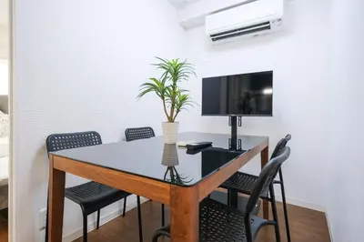 a dining room table with chairs and a plant on it at 67LEREVE Ikebukuro in Tokyo