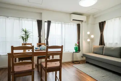 a living room with a table and chairs and a couch at 67LEREVE Ikebukuro in Tokyo
