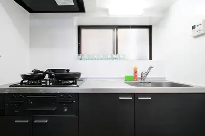 a kitchen with a stove and a sink at 67LEREVE Ikebukuro in Tokyo