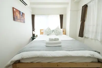 a bedroom with a bed with two towels on it at 67LEREVE Ikebukuro in Tokyo