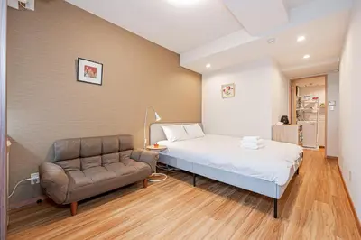 a bedroom with a bed and a chair at Sohome Otsuka Hotel in Tokyo
