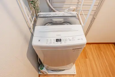 a washing machine in the corner of a room at Sohome Otsuka Hotel in Tokyo