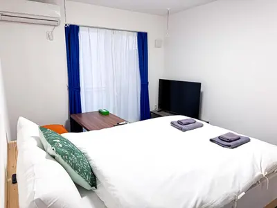 a bedroom with a large white bed and a television at 3mins to Oshiage station and Tokyo Skytree in Tokyo