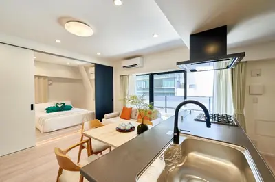 a kitchen with a sink and a living room with a bed at livecasa\u8535\u524d brand-new hotel, a 3-minute walk from Asakusa Kuramae Statio in Tokyo