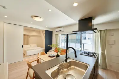 a kitchen with a sink and a living room at livecasa\u8535\u524d brand-new hotel, a 3-minute walk from Asakusa Kuramae Statio in Tokyo