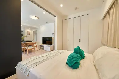 a bedroom with a bed with a stuffed animal on it at livecasa\u8535\u524d brand-new hotel, a 3-minute walk from Asakusa Kuramae Statio in Tokyo
