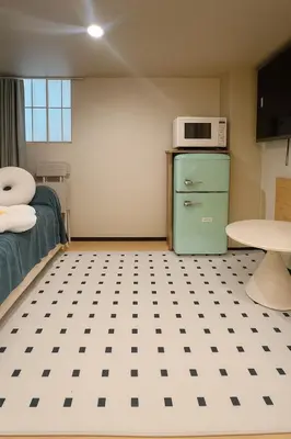 a room with a green refrigerator and a microwave at \u8aa0\u5bb6 Makoto Hotel in Tokyo