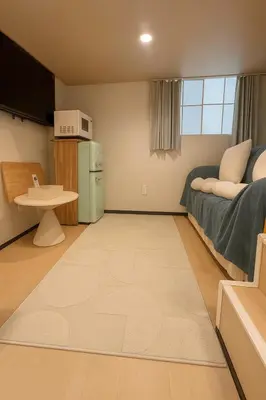 a small room with a bed and a refrigerator at \u8aa0\u5bb6 Makoto Hotel in Tokyo