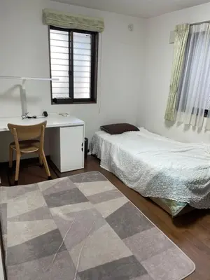 a bedroom with a bed and a desk and a chair at Lily in Tokyo