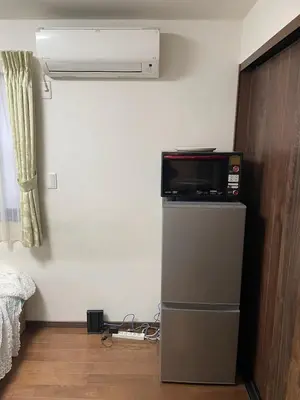 a room with a television on top of a refrigerator at Lily in Tokyo