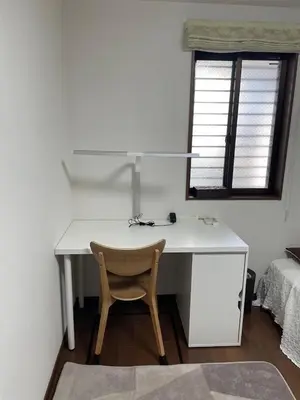 a desk with a chair in a room with a window at Lily in Tokyo