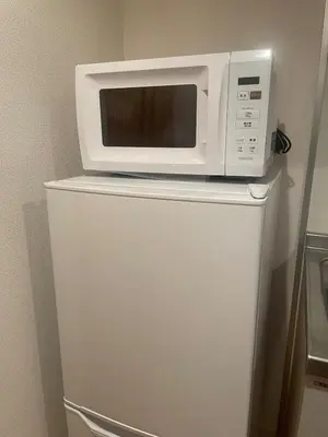 a microwave sitting on top of a refrigerator at Walk to JR Shinjuku - Grand Écru II 605 - Balcony & Kitchen in Tokyo