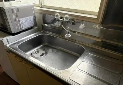 a stainless steel sink in a kitchen with a microwave at RHK Guest House102 in Tokyo