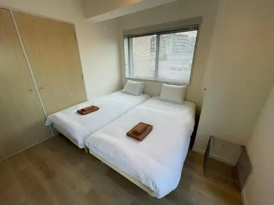 a small bedroom with a bed with a tray on it at \u30a2\u30f3\u30c9\u30b9\u30c6\u30a4\u592a\u5b50\u58022\u4e01\u76ee in Tokyo