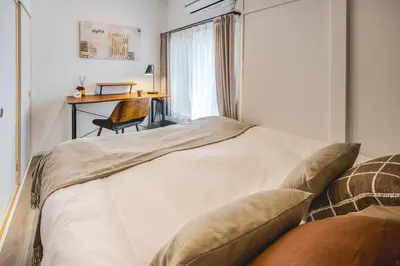 a bedroom with a bed with a desk and a chair at \u3059\u307f\u308c\u306e\u5bbf in Tokyo