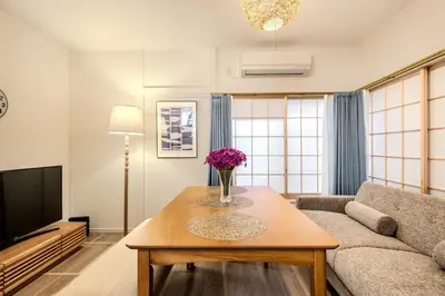 a living room with a couch and a table with flowers on it at \u3059\u307f\u308c\u306e\u5bbf in Tokyo