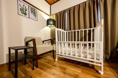 a crib in a room with a chair and a table at Shibuya House in Tokyo