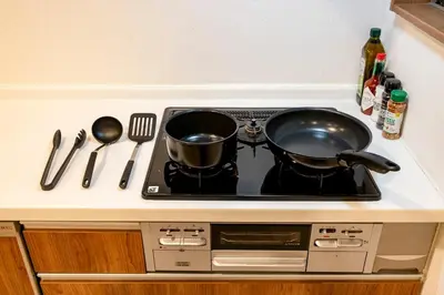 a stove top with two pots and pans on it at Shibuya House in Tokyo