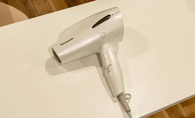 a hair dryer sitting on top of a white table at Shibuya House in Tokyo