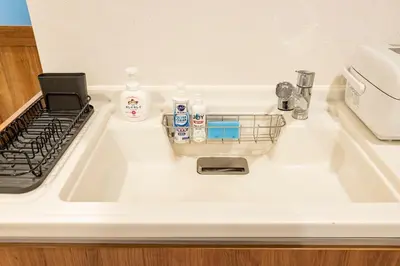 a kitchen sink with a dish drying rack on it at Shibuya House in Tokyo