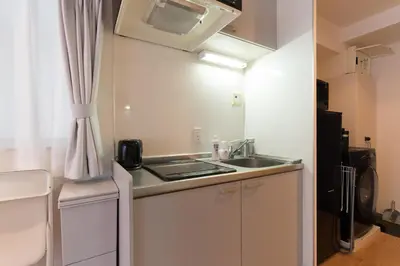 a small kitchen with a sink and a microwave at ORIENS SHIBUYA Stylish Apt - Steps to Scramble crossing - Foodie hub Ebisu & Daikanyama in Tokyo