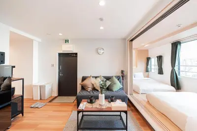 a living room with a couch and a bed at SAIEI HOTEl \u65b0\u5bbf in Tokyo