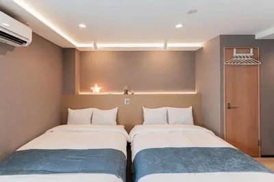 two beds in a small room with at SAIEI HOTEl \u65b0\u5bbf in Tokyo