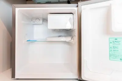 an empty refrigerator with its door open in a kitchen at SAIEI HOTEl \u65b0\u5bbf in Tokyo