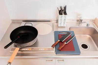 a kitchen stove with a pan and utensils on it at SAIEI HOTEl \u65b0\u5bbf in Tokyo