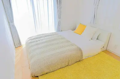 a bed in a room with a large window at Zen Luxe in Tokyo