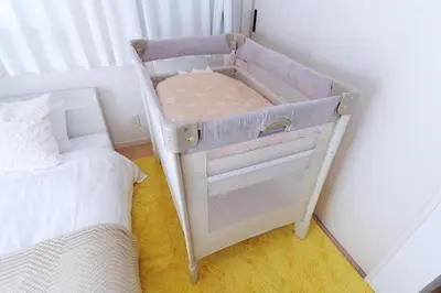 a crib in a room next to a bed at Zen Luxe in Tokyo