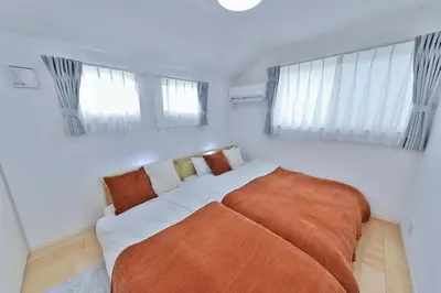 a bedroom with a large bed and two windows at Zen Luxe in Tokyo
