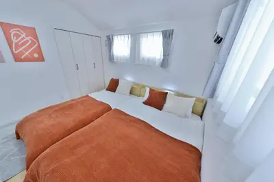 a bedroom with a large bed with an orange blanket at Zen Luxe in Tokyo