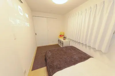 a small bedroom with a bed and a table at Zen Luxe in Tokyo