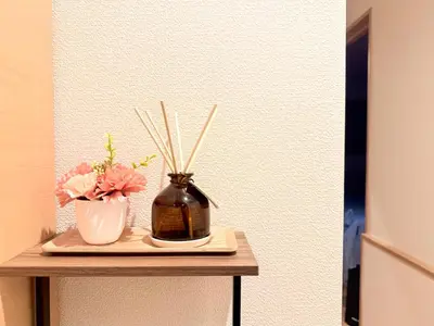 a table with a vase and flowers on it at 池袋銀婚屋 GINKOU's HOUSE -- 2 min train to Ikebukuro Sunshine City in Tokyo
