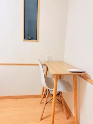 a wooden table with a white chair and a mirror at 池袋銀婚屋 GINKOU's HOUSE -- 2 min train to Ikebukuro Sunshine City in Tokyo