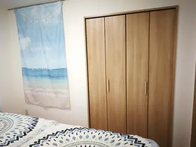 a bedroom with a bed and a wooden cabinet at \u611b\u306e\u5c4b\u6c11\u6cca\u65b0\u5bbf in Tokyo