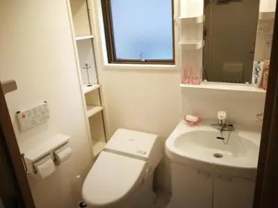 a small bathroom with a toilet and a sink at \u611b\u306e\u5c4b\u6c11\u6cca\u65b0\u5bbf in Tokyo