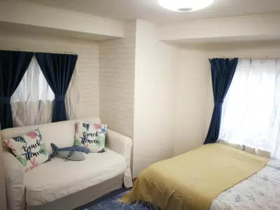 a bedroom with a white couch and a window at \u611b\u306e\u5c4b\u6c11\u6cca\u65b0\u5bbf in Tokyo