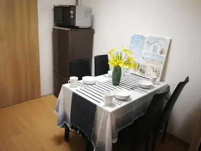 a table with a vase of yellow flowers on it at \u611b\u306e\u5c4b\u6c11\u6cca\u65b0\u5bbf in Tokyo